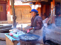Women cooking snacks over a live coal